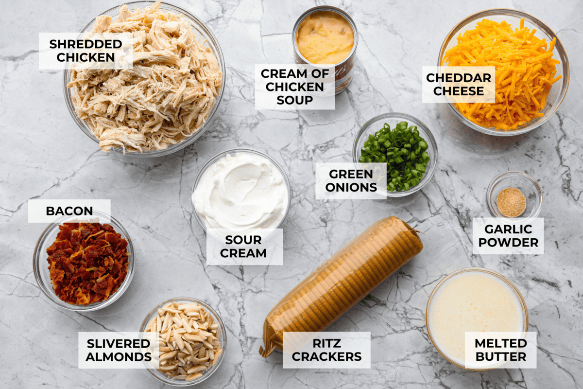 Neiman Marcus Chicken Casserole is boujee on a budget. It’s creamy, comforting, and topped with a buttery, golden cracker crust. Inspired by a recipe from the iconic department store’s café, this casserole tastes amazing and comes together fast. Overhead shot of labeled Neiman Marcus chicken casserole ingredients.