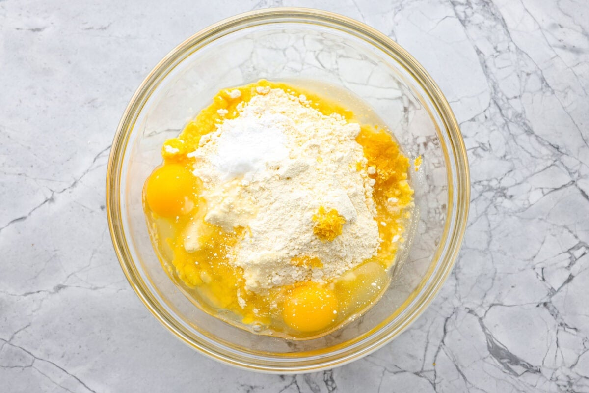 Bowl of eggs, cake mix, baking powder, vegetable oil and lemon zest. 