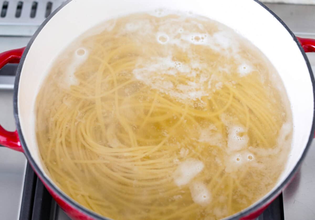 Spaghetti Margherita has been a family favorite since I was a kid, though we just called it “pasta with tomato and basil.” It’s simple, fresh, and so full of flavor, even my meat-loving husband can’t get enough! Spaghetti noodles cooking in a pot of water.