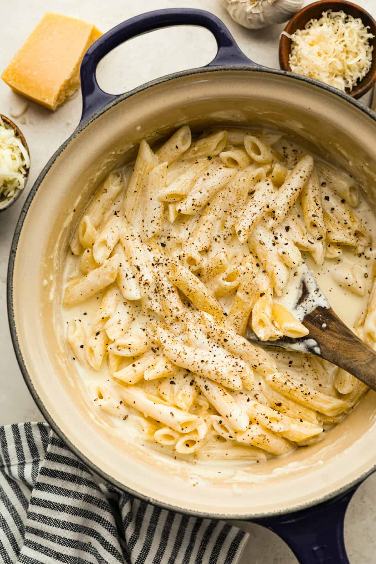 Craving something cozy, cheesy, and totally irresistible? My four cheese pasta brings comfort with a creamy ricotta base and a melty mix of easy-to-find Italian cheeses. It’s indulgent and totally hits the flavor jackpot! Four cheese pasta cooked and seasoned with pepper in a pan.