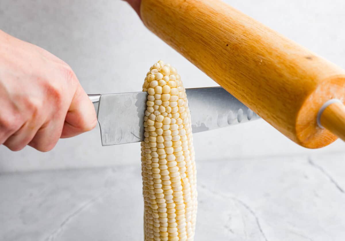 someone hitting the back of a knife blade to get the knife to go through the corn cob. 
