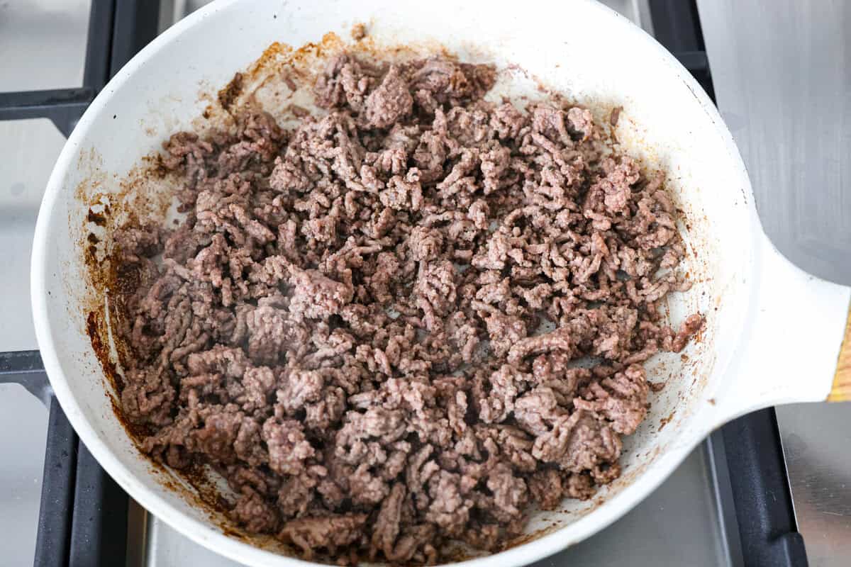 Yeehaw! My cowboy pasta salad is loaded with beef, bacon, beans, and all the fixings for all you cowboy lovers. You'll get all the flavors of the Wild West tossed in the tastiest cowboy salad dressing. Ground beef cooking in a skillet.