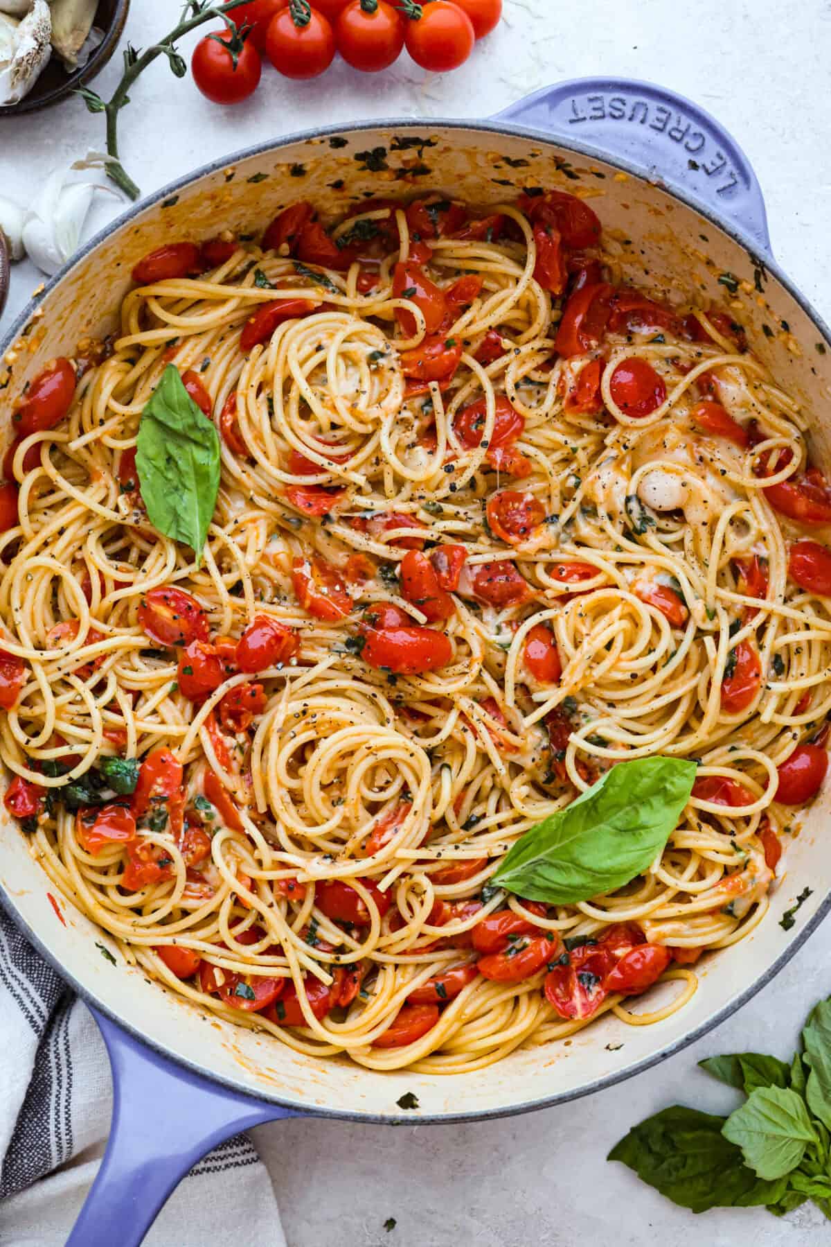 Spaghetti Margherita has been a family favorite since I was a kid, though we just called it “pasta with tomato and basil.” It’s simple, fresh, and so full of flavor, even my meat-loving husband can’t get enough! Overhead shot of garnished spaghetti margherita in a skillet.