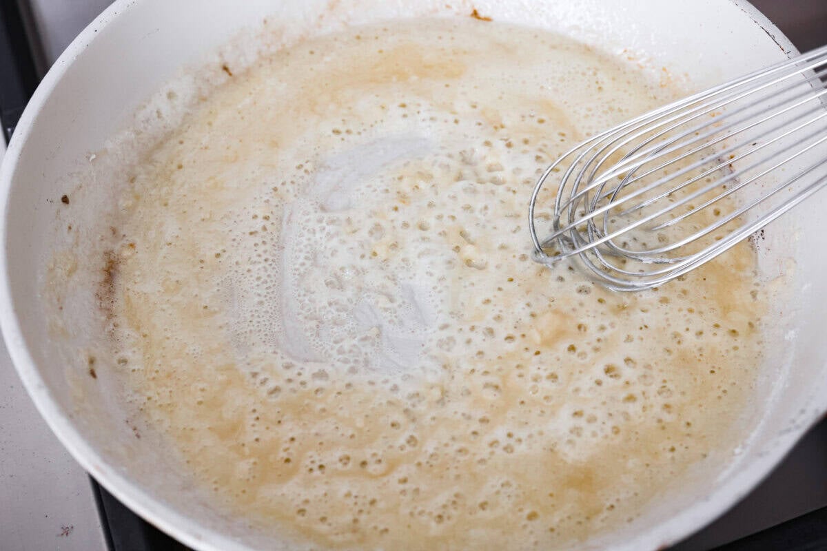 They don’t call it Marry Me Lasagna for nothing! One bite of the creamy sauce, tender chicken, and melty cheese, and everyone will be saying, "YES!" Melted butter, garlic and flour being whisked together to create a roux.