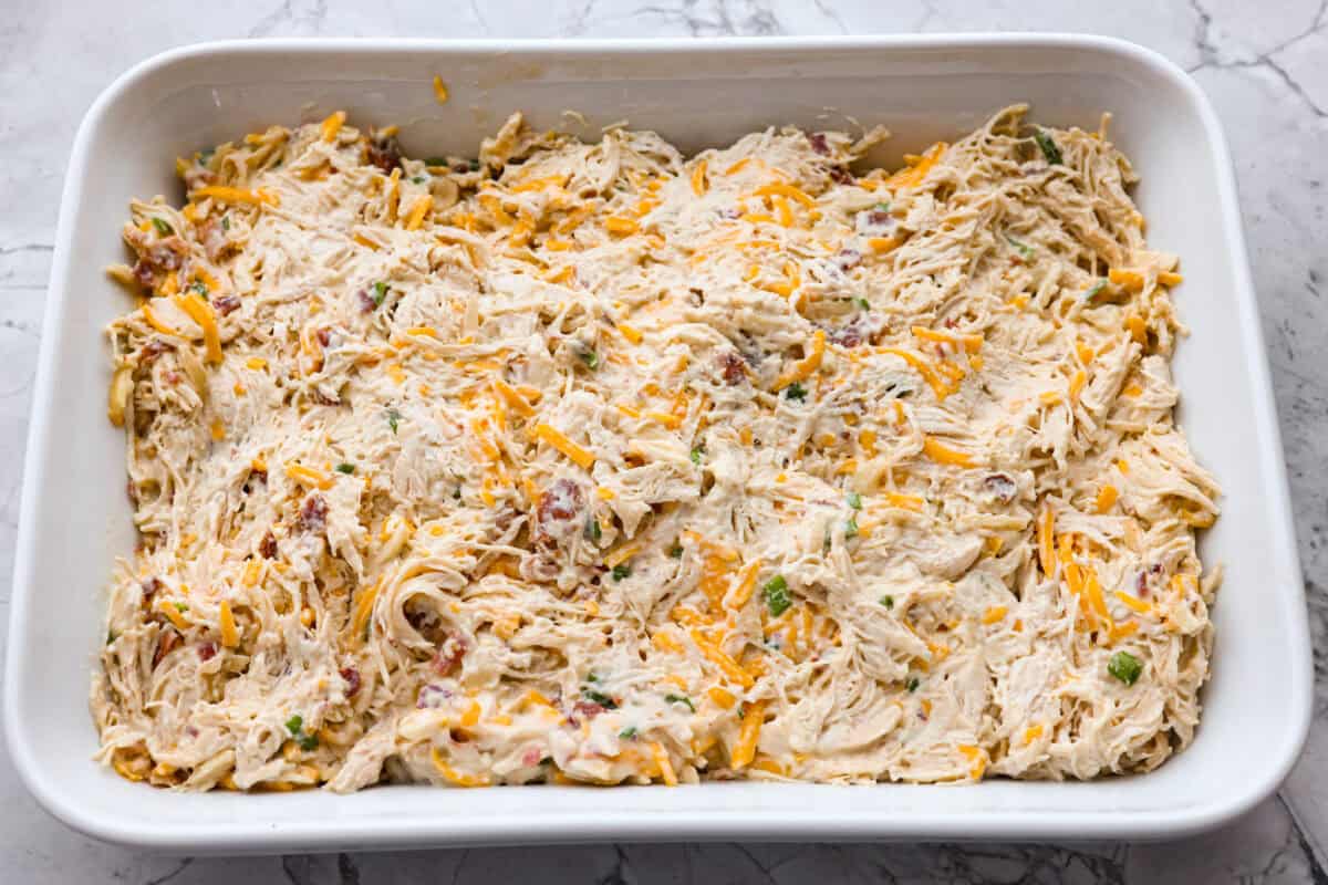 Neiman Marcus Chicken Casserole is boujee on a budget. It’s creamy, comforting, and topped with a buttery, golden cracker crust. Inspired by a recipe from the iconic department store’s café, this casserole tastes amazing and comes together fast. All of the ingredients spread out in a casserole dish.