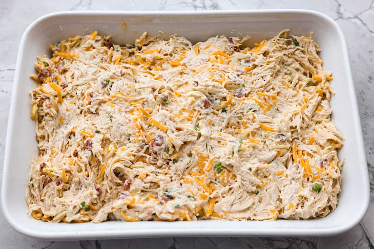 Neiman Marcus Chicken Casserole is boujee on a budget. It’s creamy, comforting, and topped with a buttery, golden cracker crust. Inspired by a recipe from the iconic department store’s café, this casserole tastes amazing and comes together fast. All of the ingredients spread out in a casserole dish.