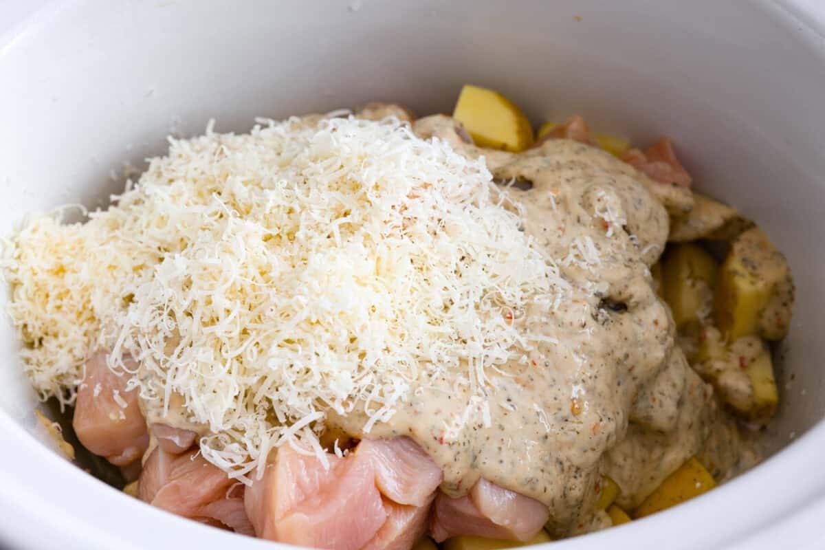 This viral slow cooker Parmesan garlic chicken has juicy meat, tender potatoes, and a sauce so rich and creamy that scooping it with a spoon won’t cut it. You’ll want to drink it, or let’s be real, bathe in it. Sauce, cheese and broth added to the slow cooker.