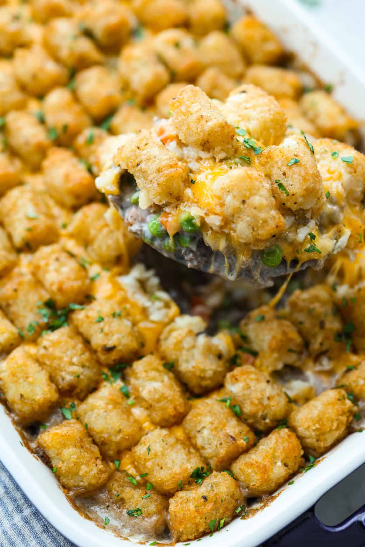 If you love shepherd’s pie, you’ve got to try this Tater Tot Casserole! It’s the ultimate lazy-girl version, with tots instead of mashed potatoes, melty cheese, hearty beef, and total comfort in every bite. The kids will absolutely devour it. Close up of the scoop of tater tot casserole.