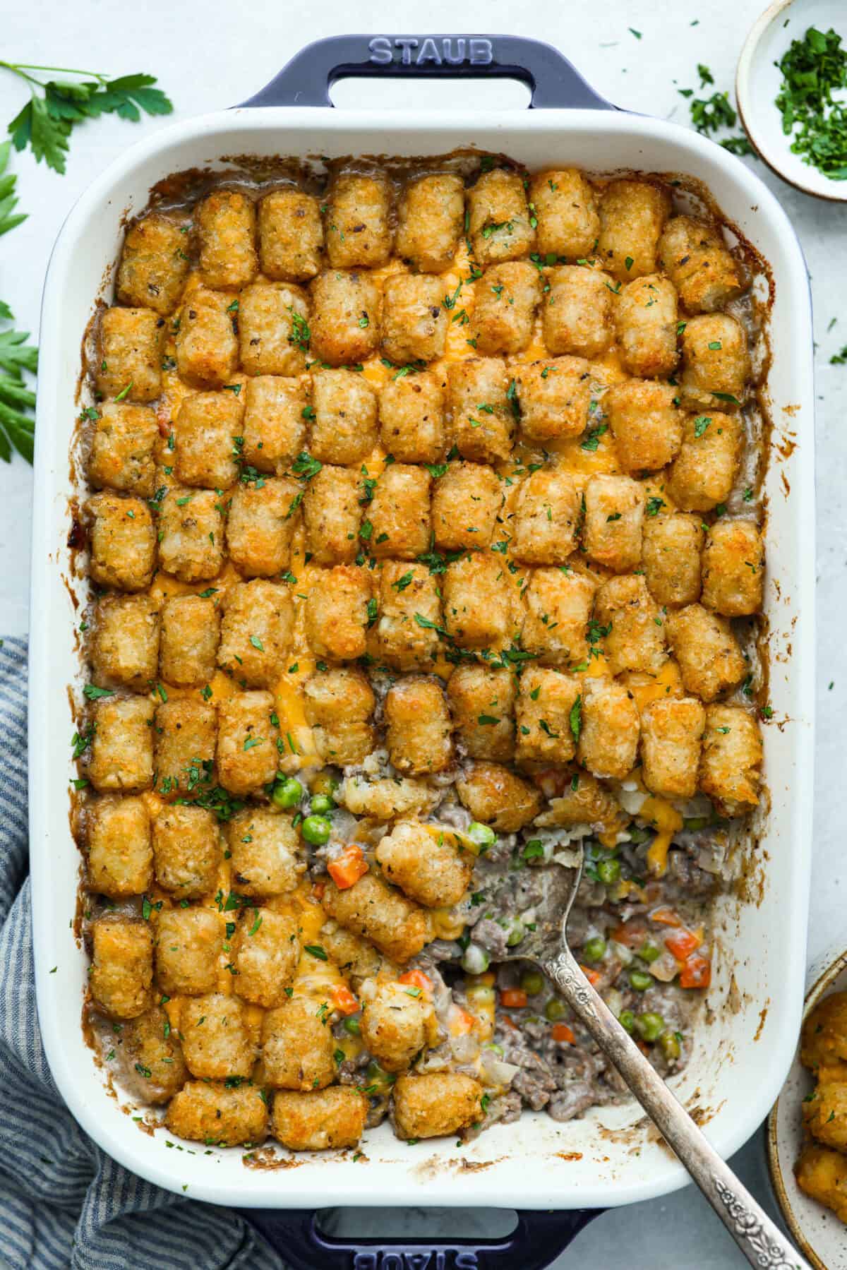 If you love shepherdโs pie, youโve got to try this Tater Tot Casserole! Itโs the ultimate lazy-girl version, with tots instead of mashed potatoes, melty cheese, hearty beef, and total comfort in every bite. The kids will absolutely devour it. Top down view of cooked tater tot casserole.