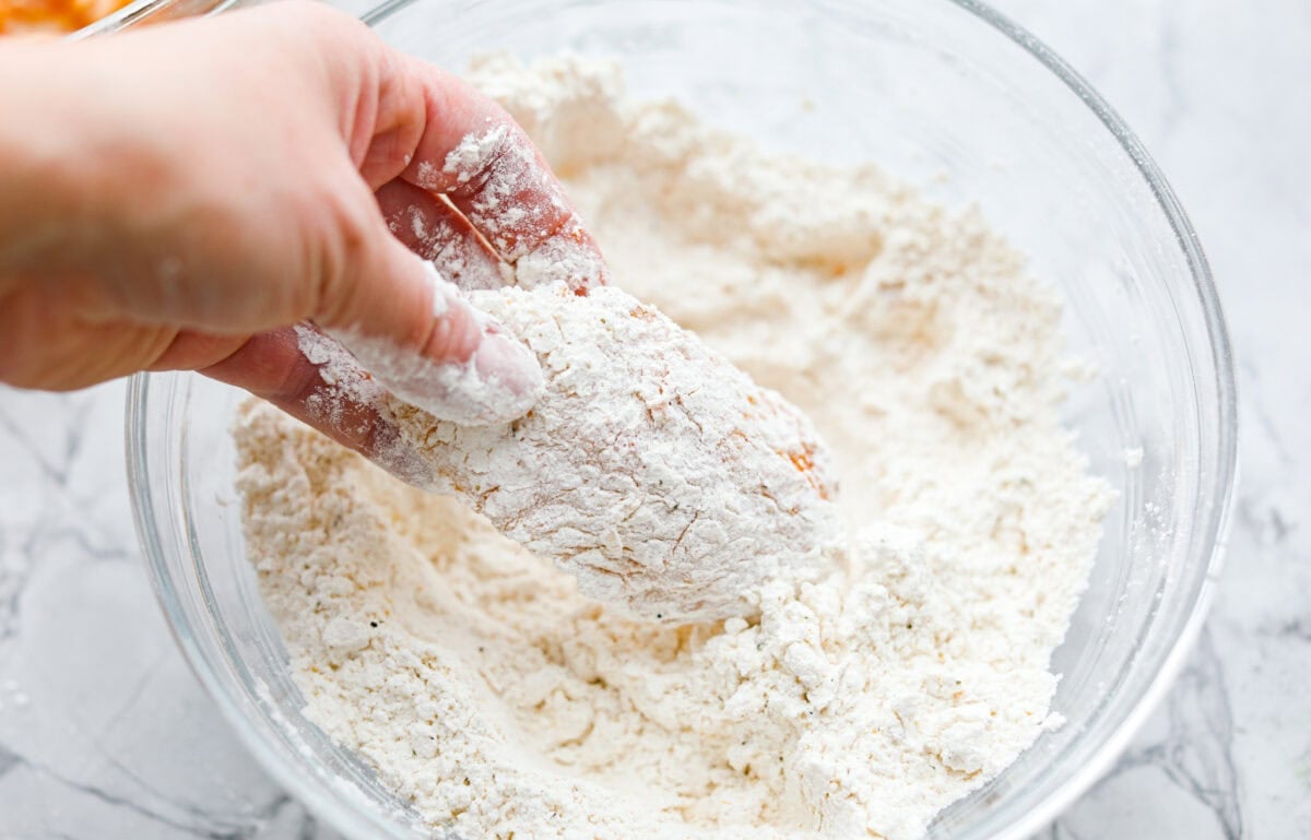 Meet your new wing obsession: Crack Wings. Salty, tangy, peppery, with a touch of sweetness. I've never seen a wing with a powder dusting so full of flavor! They are addictive because of the salty and sweet combo with that hint of heat. Someone completely coating a wing in breading.