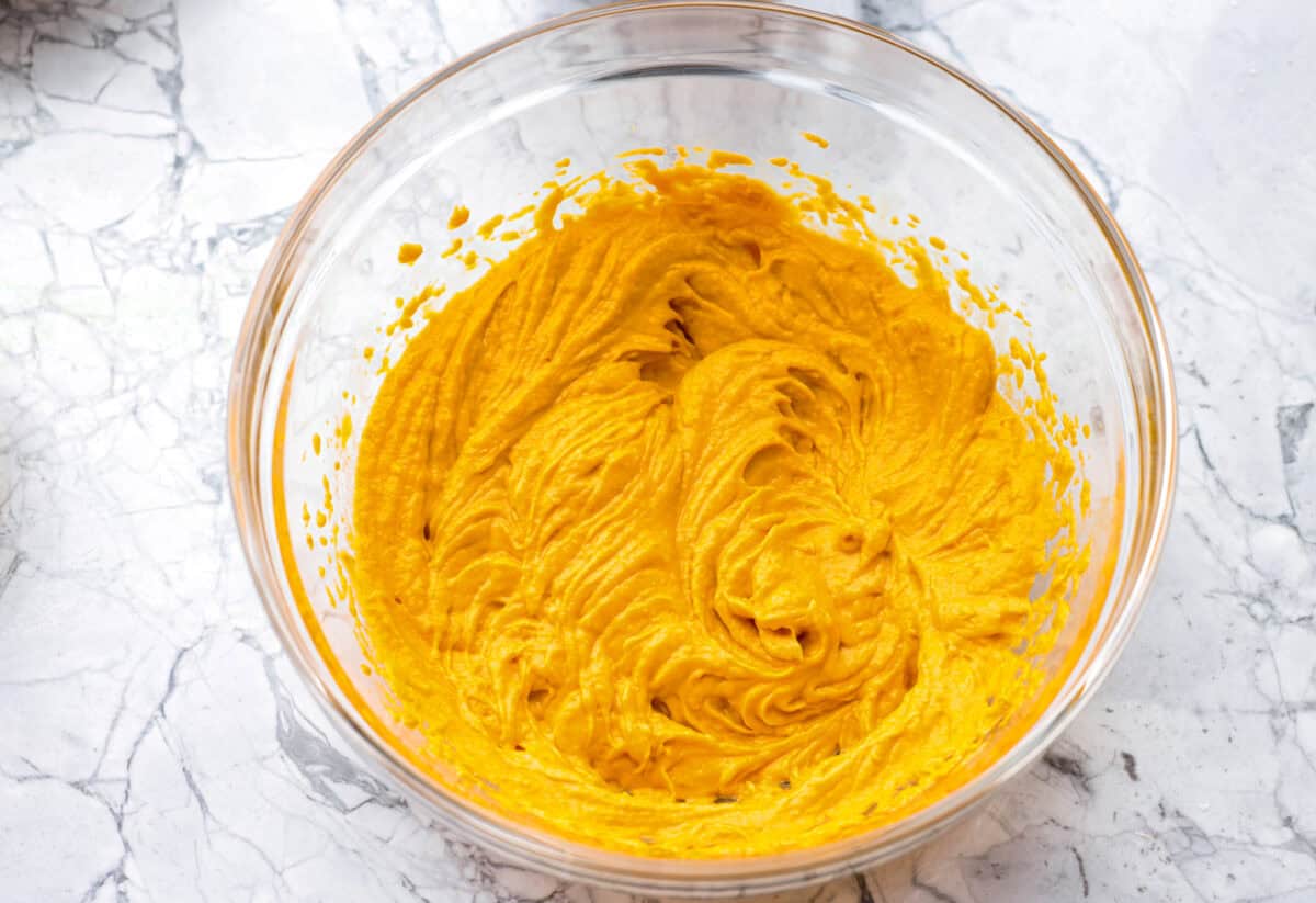 Bowl of peanut butter, pumpkin, and eggs mixed together.