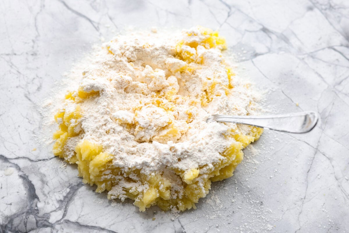 Someone mixing mashed potatoes with flour, egg, and salt. 
