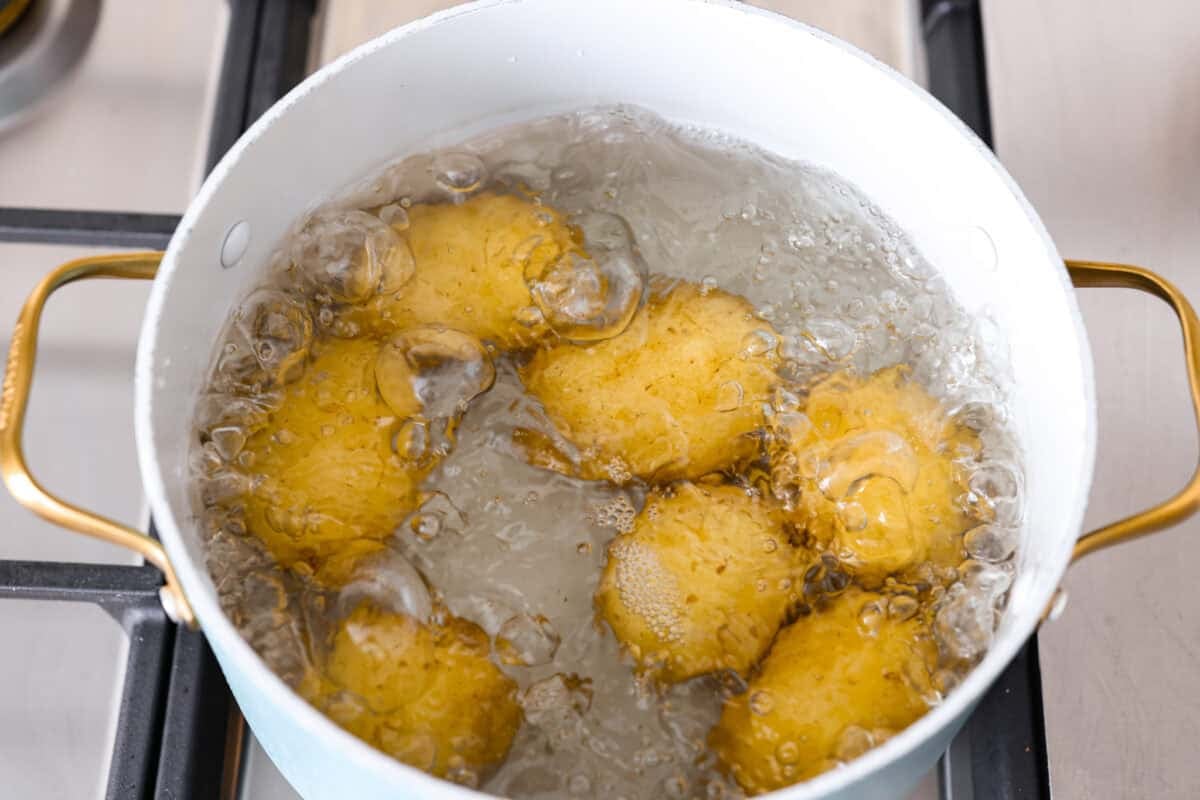 Whole potatoes boiling in water.