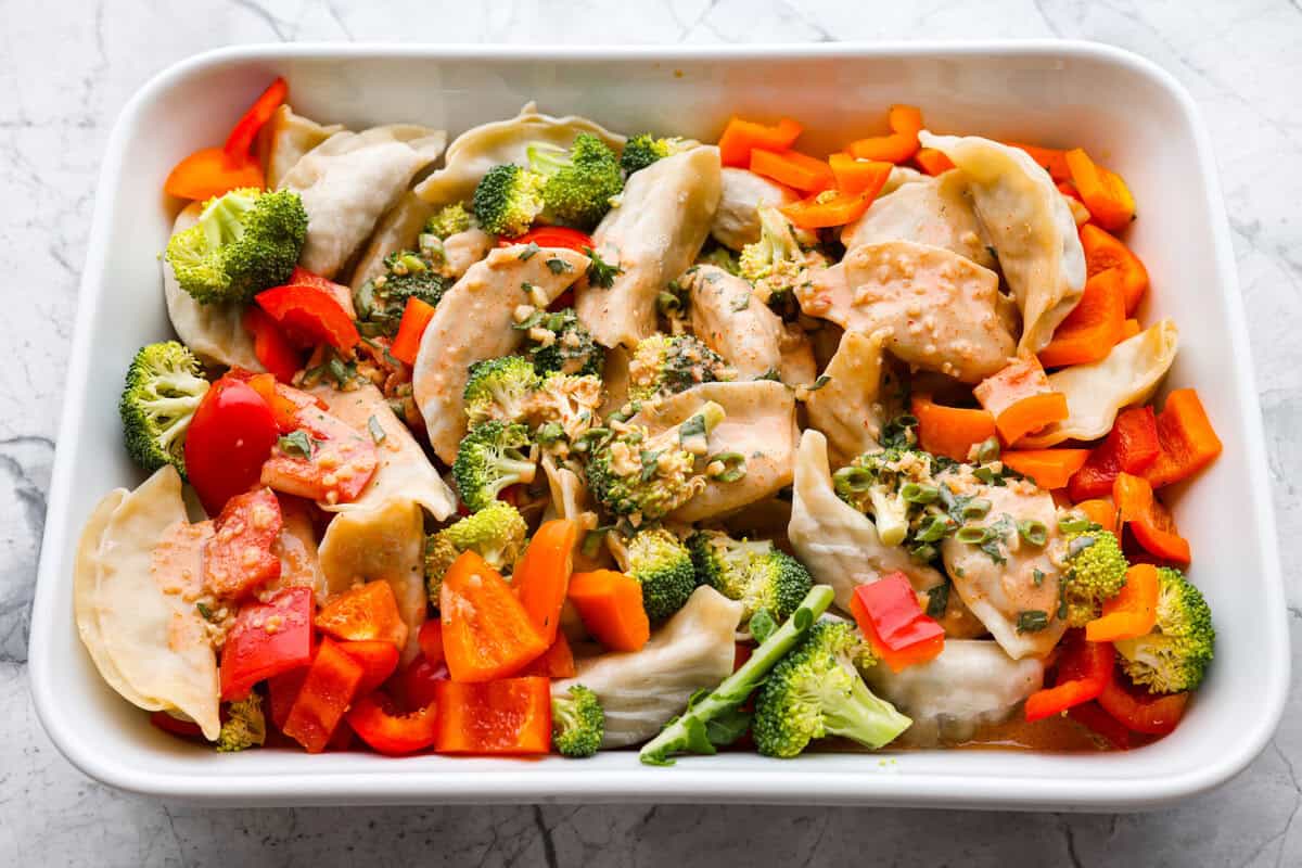 Potsticker casserole is all the tasty fun of potstickers in a warm, baked dish. Soft dumplings, fresh veggies, and a rich sauce cook together for a fast, easy, and filling meal. Sauce poured on top of the potstickers and veggies all read yto be baked.