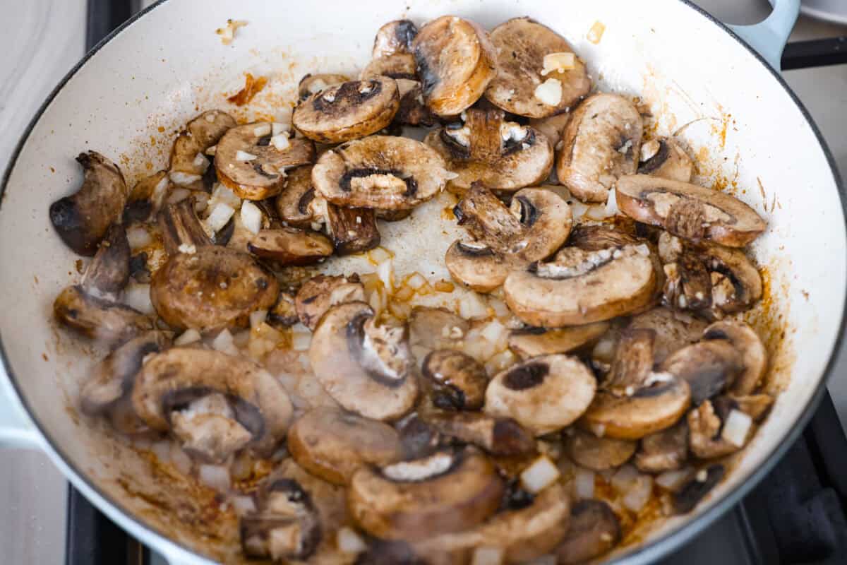 Tuscan garlic skillet chicken is one of those dinners I make and then wonder why I don’t make it more often. Juicy chicken and sun-dried tomatoes all cook together in one skillet. No heavy cream needed. Just fresh, bold flavor in 30 minutes! Mushrooms, onions, and garlic cooking in a skillet.