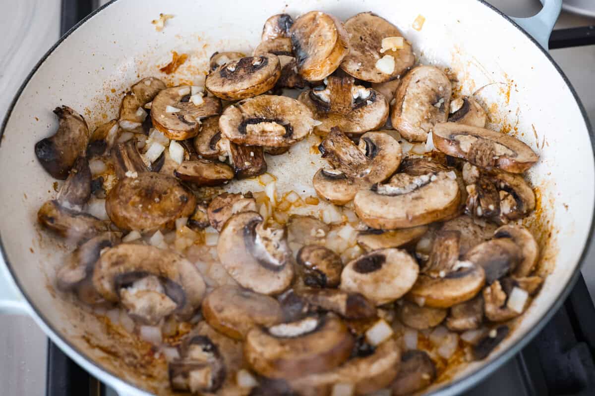 Tuscan garlic skillet chicken is one of those dinners I make and then wonder why I don’t make it more often. Juicy chicken and sun-dried tomatoes all cook together in one skillet. No heavy cream needed. Just fresh, bold flavor in 30 minutes! Mushrooms, onions, and garlic cooking in a skillet.