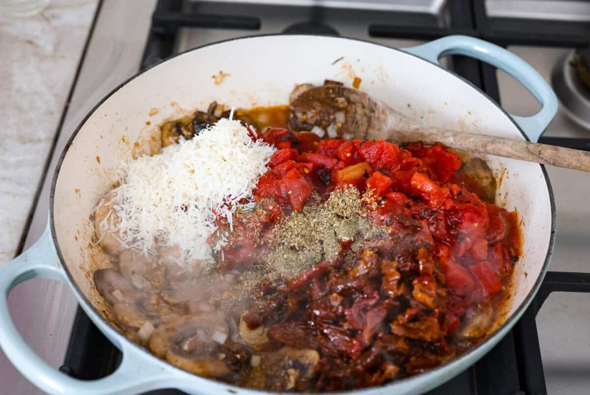 Tuscan garlic skillet chicken is one of those dinners I make and then wonder why I don’t make it more often. Juicy chicken and sun-dried tomatoes all cook together in one skillet. No heavy cream needed. Just fresh, bold flavor in 30 minutes! Tomatoes and seasonings added to the mushrooms.