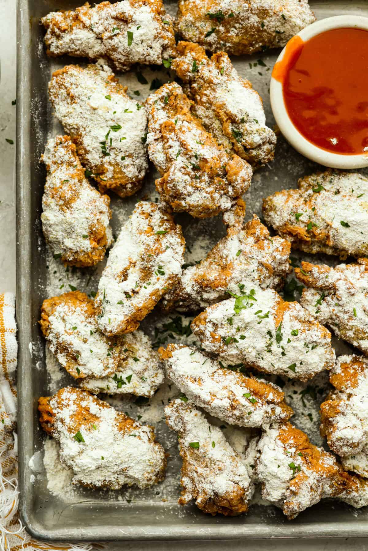 Meet your new wing obsession: Crack Wings. Salty, tangy, peppery, with a touch of sweetness. I've never seen a wing with a powder dusting so full of flavor! They are addictive because of the salty and sweet combo with that hint of heat. Cookie sheet with crack wings covered in the crack chicken seasoning powder.