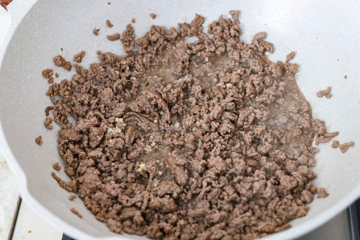 You guys are obsessed with my Korean Ground Beef rice bowls, so I decided I needed a noodle version. Tender beef, savory goodness, and those irresistible Korean flavors all wrapped up in one slurp-worthy Korean Beef Noodle dish. Ground beef and garlic cooking in a skillet.