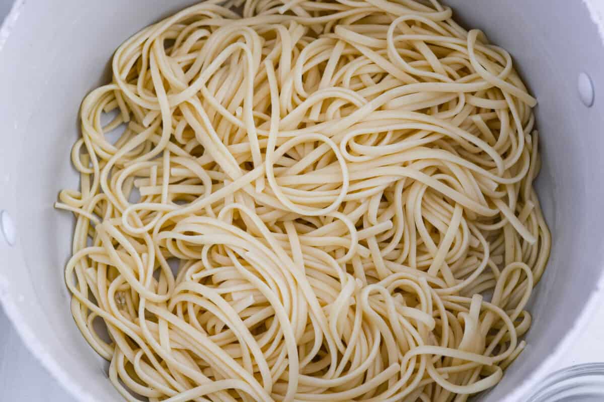 Cooked noodles drained in the bottom of a pot.