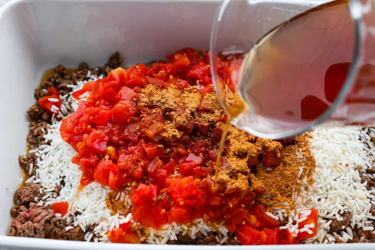 https://therecipecritic.com/homemade-bone-broth/ Someone pouring beef broth into the rice and beef mixture.