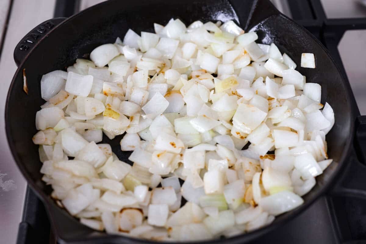 My Tennessee Onion Dip is a family-party legend. Everyone always begs me to bring it, and for good reason, the sweet onion flavor baked with gooey cheese and seasonings is absolutely irresistible! Skillet full of chopped onions cooking.