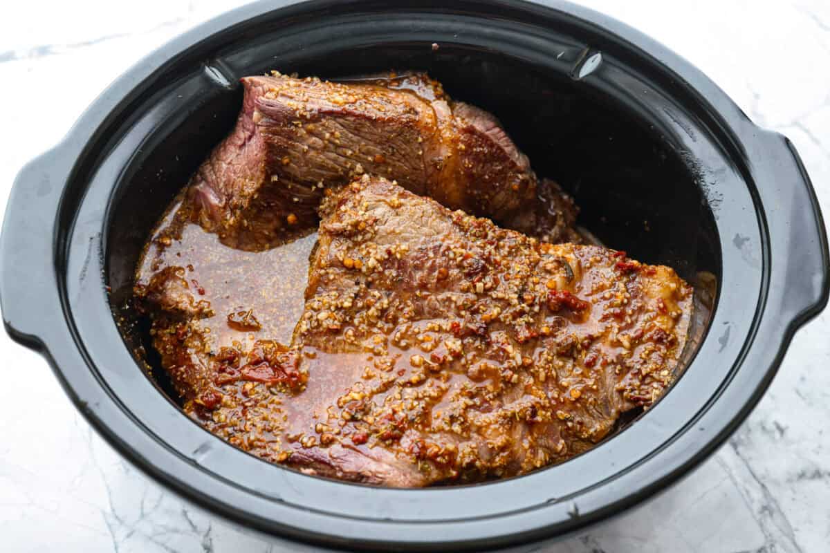 Slow cooker barbacoa beef simmers all day in smoky chipotle, tangy lime, and warm spices until it falls apart. It’s perfect for tacos, burritos, bowls, or nachos, all with that taquería-style flavor at home. Sauce poured over the browned beef in the crockpot.