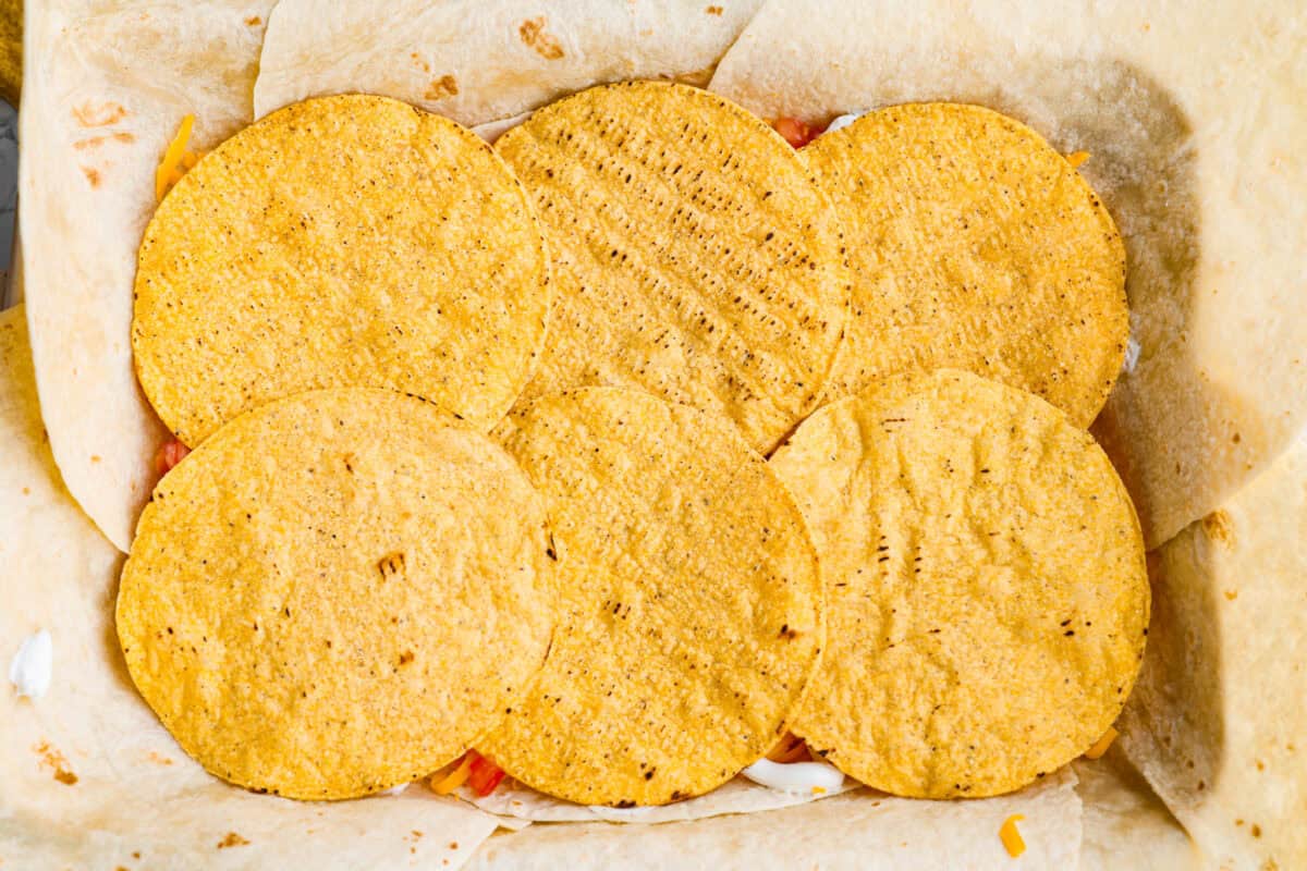 Tostada shells layered on top of the sour cream layer. 