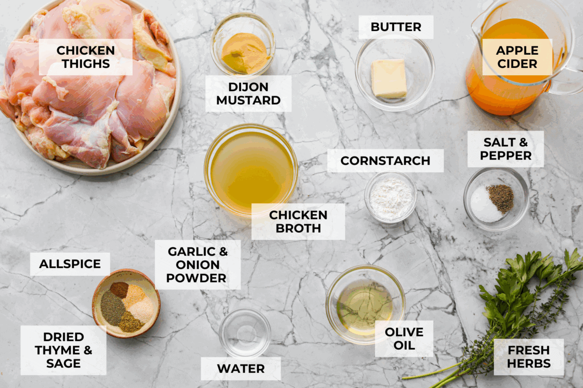 Apple cider chicken thighs bring all the best fall flavors to your plate! Juicy chicken, caramelized apples, and a rich cider sauce for the ultimate cozy dinner. Overhead shot of labeled ingredients.
