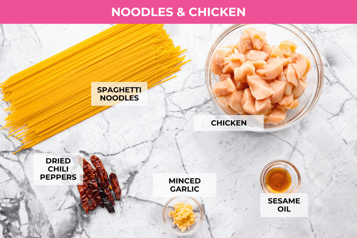 Skip the takeout, these Kung Pao Chicken Noodles are spicy, saucy, and loaded with flavor! Tender chicken, chewy noodles, crunchy peanuts, and a kick of heat all come together in one quick and easy dish that’s perfect for weeknight dinners. Overhead shot of then labeled chicken and noodles ingredients.