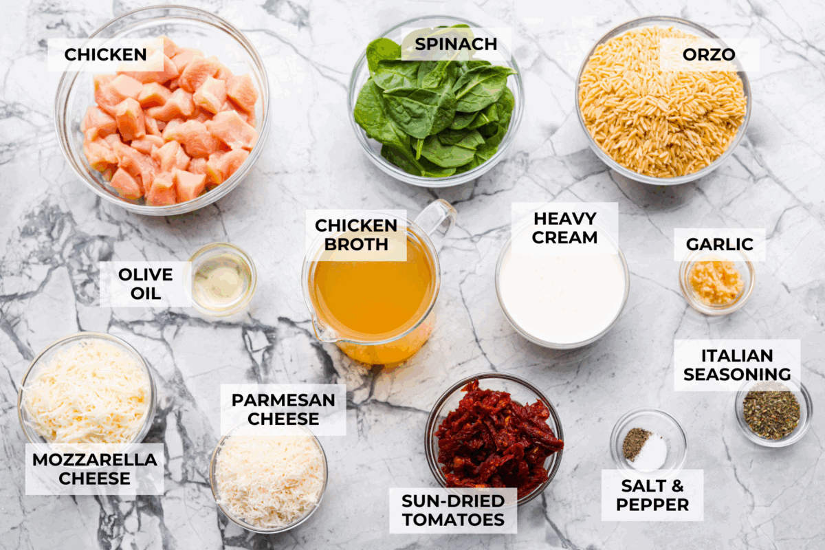 This creamy Tuscan chicken orzo bake is the kind of dinner you’ll want on repeat! Tender chicken, orzo, and sun-dried tomatoes bake together in one pan for an easy, comforting weeknight meal. Overhead shot of labeled tuscan chicken orzo bake ingredients.