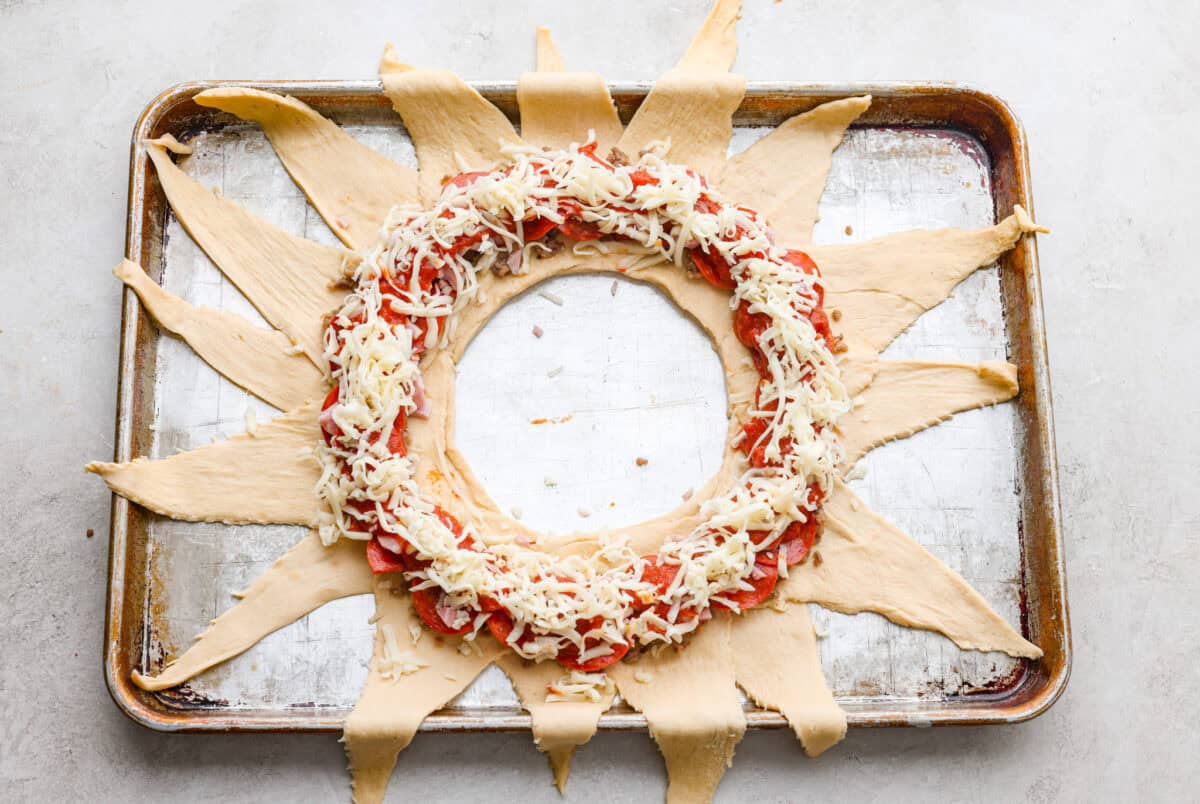 Pizza night just got a glow-up! This fun pull-apart pizza ring is perfect for family dinner, game day, or a party snack. Easy to make, endlessly customizable, and totally kid-approved, you’ll be reaching for slice after slice! Cheese sprinkled over the top of the toppings.