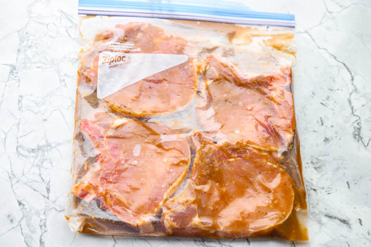 Pork chops in marinade in a sealed gallon sized zip lock bag.