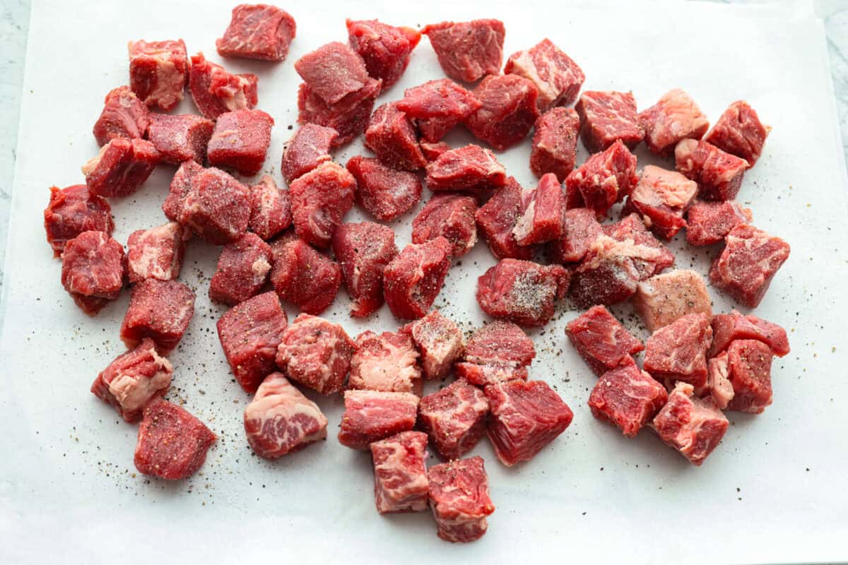 Do you like your chili with beans or without? This authentic Texas chili keeps it classic. Just bold, tender chuck roast, without beans. It has a rich, smoky flavor in every bite. Chuck roast cute into cubes and seasoned on a cutting board.