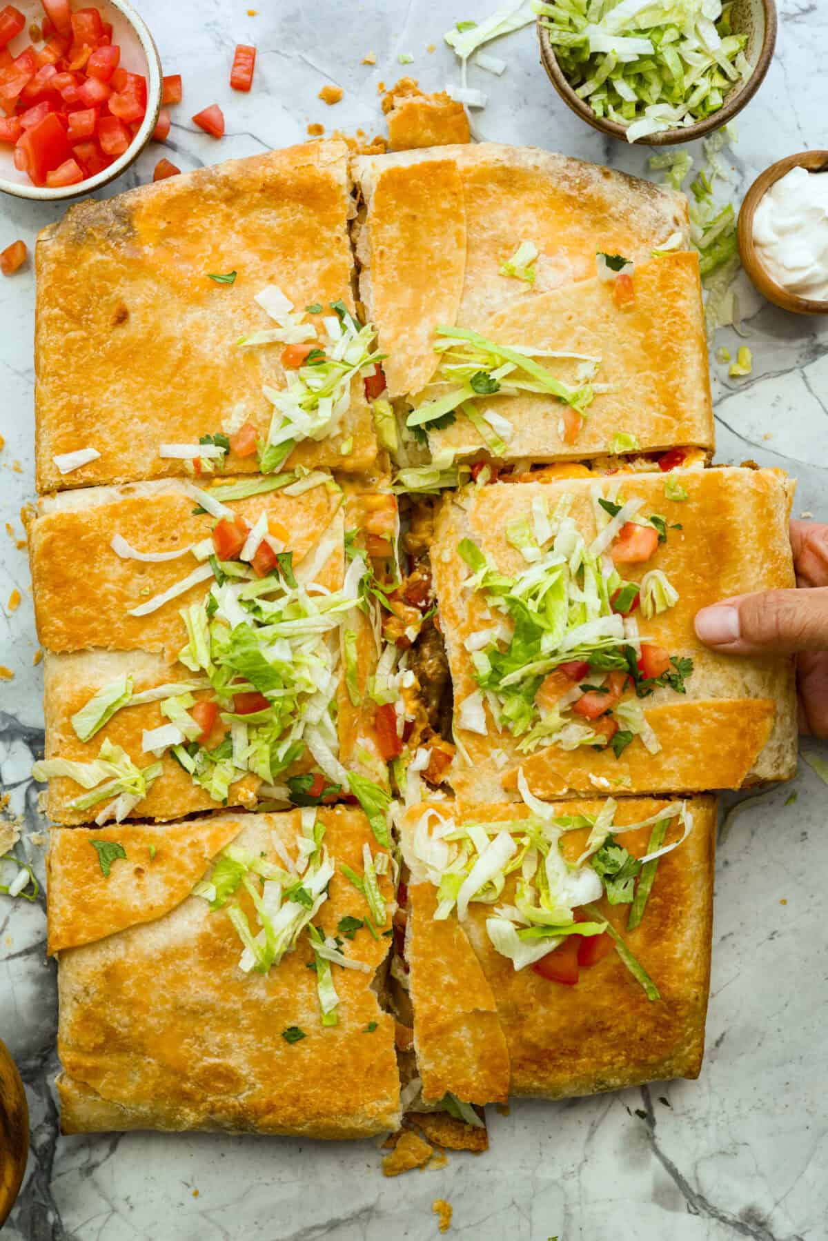Overhead shot of crunchwrap casserole topped with shredded lettuce, tomatoes and cilantro.