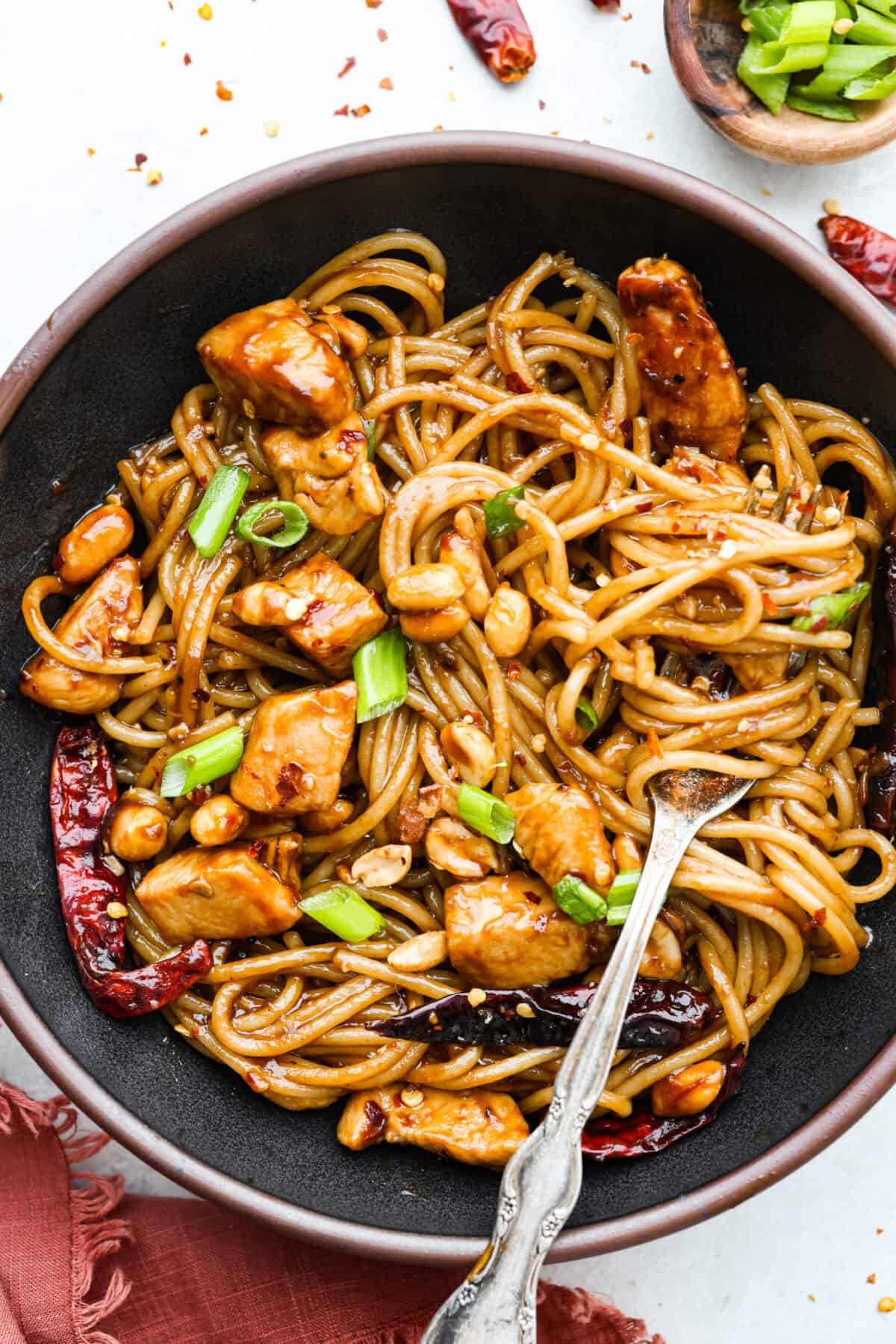 Skip the takeout, these Kung Pao Chicken Noodles are spicy, saucy, and loaded with flavor! Tender chicken, chewy noodles, crunchy peanuts, and a kick of heat all come together in one quick and easy dish that’s perfect for weeknight dinners. Serving bowl of Kung Pao chicken noodles.