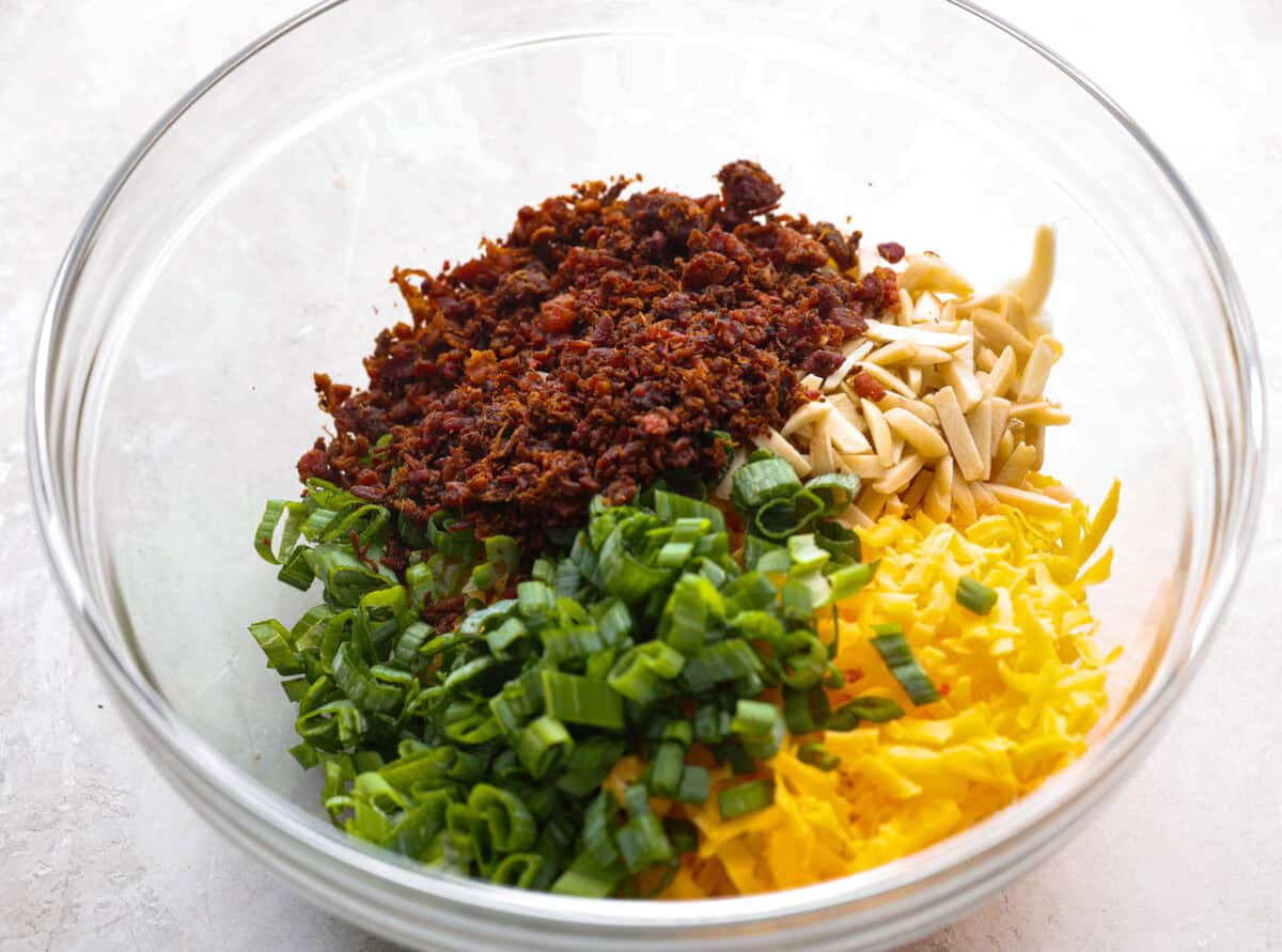 Million Dollar Dip, also known as the famous Neiman Marcus Dip, is creamy, cheesy, and loaded with almonds, green onions, and bacon. It’s the ultimate appetizer that everyone asks for the recipe. Ingredients added to a mixing bowl.