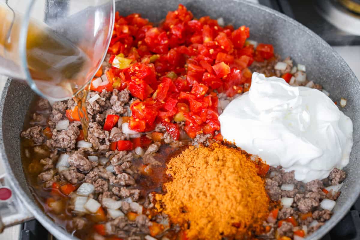 Doritos casserole is everything you love about taco night, just with a crunchy, cheesy twist! It’s crispy, crunchy, creamy, flavorful, and so easy to throw together. Who can say no to chips for dinner? Tomatoes, sour cream, broth, and seasonings added to the meat mixture in the skillet.