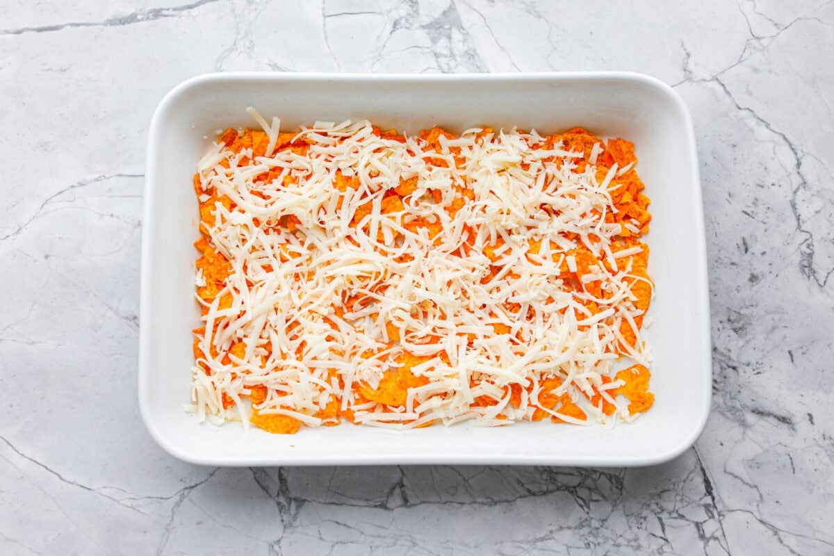 Doritos casserole is everything you love about taco night, just with a crunchy, cheesy twist! It’s crispy, crunchy, creamy, flavorful, and so easy to throw together. Who can say no to chips for dinner? Chips and cheese layered in the bottom of a baking dish.