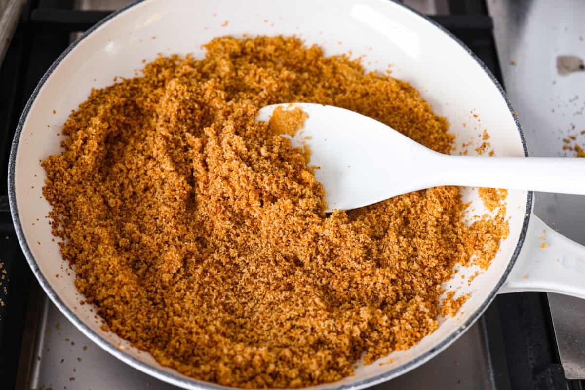Every time I make garlic bread, my family eats every last piece! This garlic bread pasta has all the same buttery, garlicky flavor you love, just in pasta form. It’s creamy, comforting, and easy to make! And there is plenty to go around! Breadcrumbs browning in a skillet on the stove top.