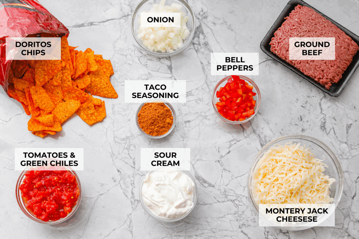 Doritos casserole is everything you love about taco night, just with a crunchy, cheesy twist! It’s crispy, crunchy, creamy, flavorful, and so easy to throw together. Who can say no to chips for dinner? Overhead shot of labeled Doritos casserole ingredients.
