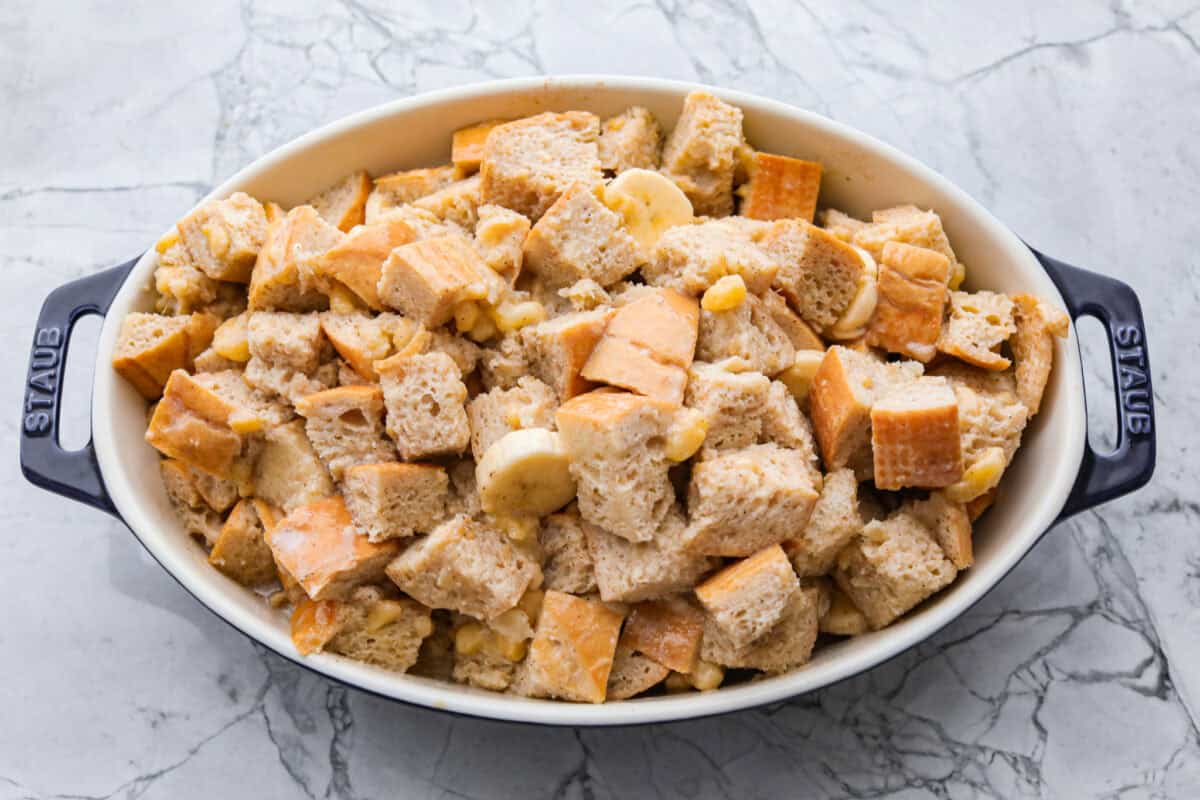 If you love classic bread pudding, you’ve got to try banana bread pudding. Sweet banana flavor, a soft custardy center, and golden edges that taste like heaven. It’s easy to throw together and is perfect for brunch or even dessert! Bread pudding ingredients added to the baking dish ready to go in the oven.