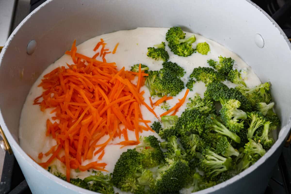 I promise that with just one bite of this copycat Panera Bread Broccoli Cheddar Soup, you'll be hooked! It's ultra creamy with broccoli, shredded carrots, and a hint of nutmeg, all cooked together with melted cheese. This soup is delicious and easy to make! Broccoli and carrots added to the soup base.