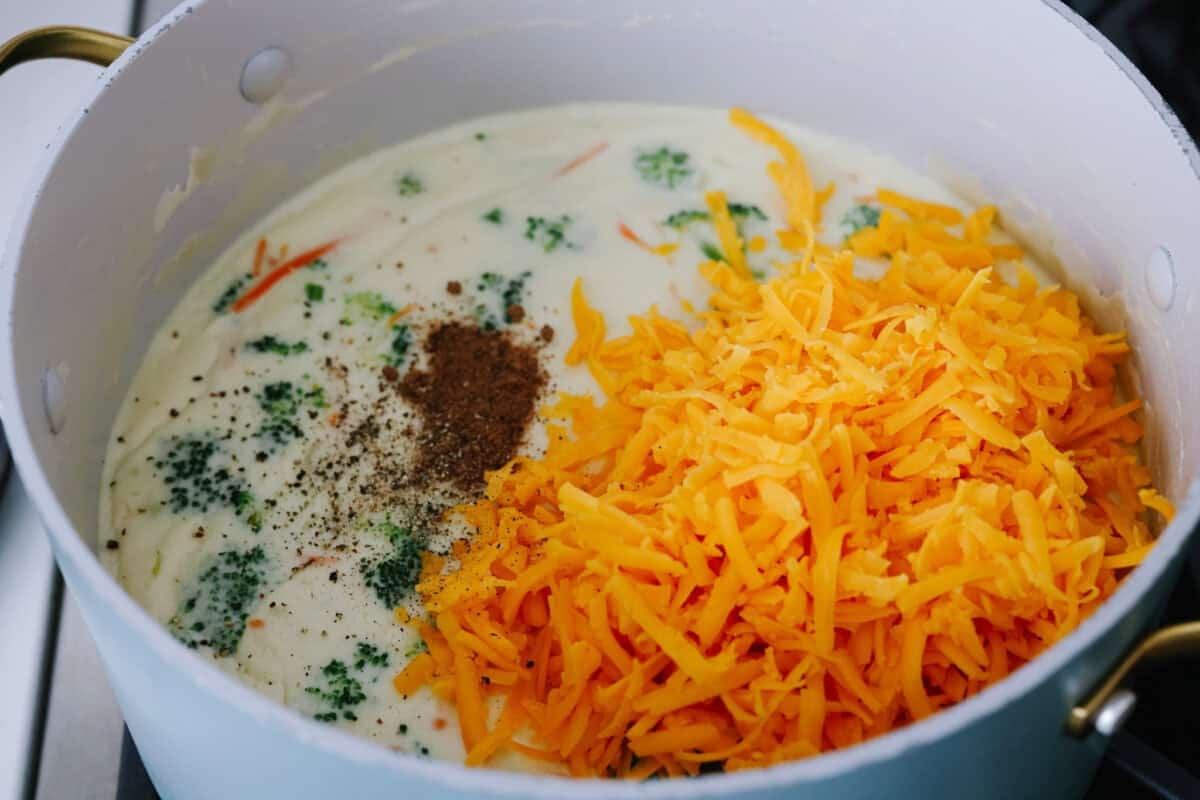 I promise that with just one bite of this copycat Panera Bread Broccoli Cheddar Soup, you'll be hooked! It's ultra creamy with broccoli, shredded carrots, and a hint of nutmeg, all cooked together with melted cheese. This soup is delicious and easy to make! Cheese and seasonings added to the soup.