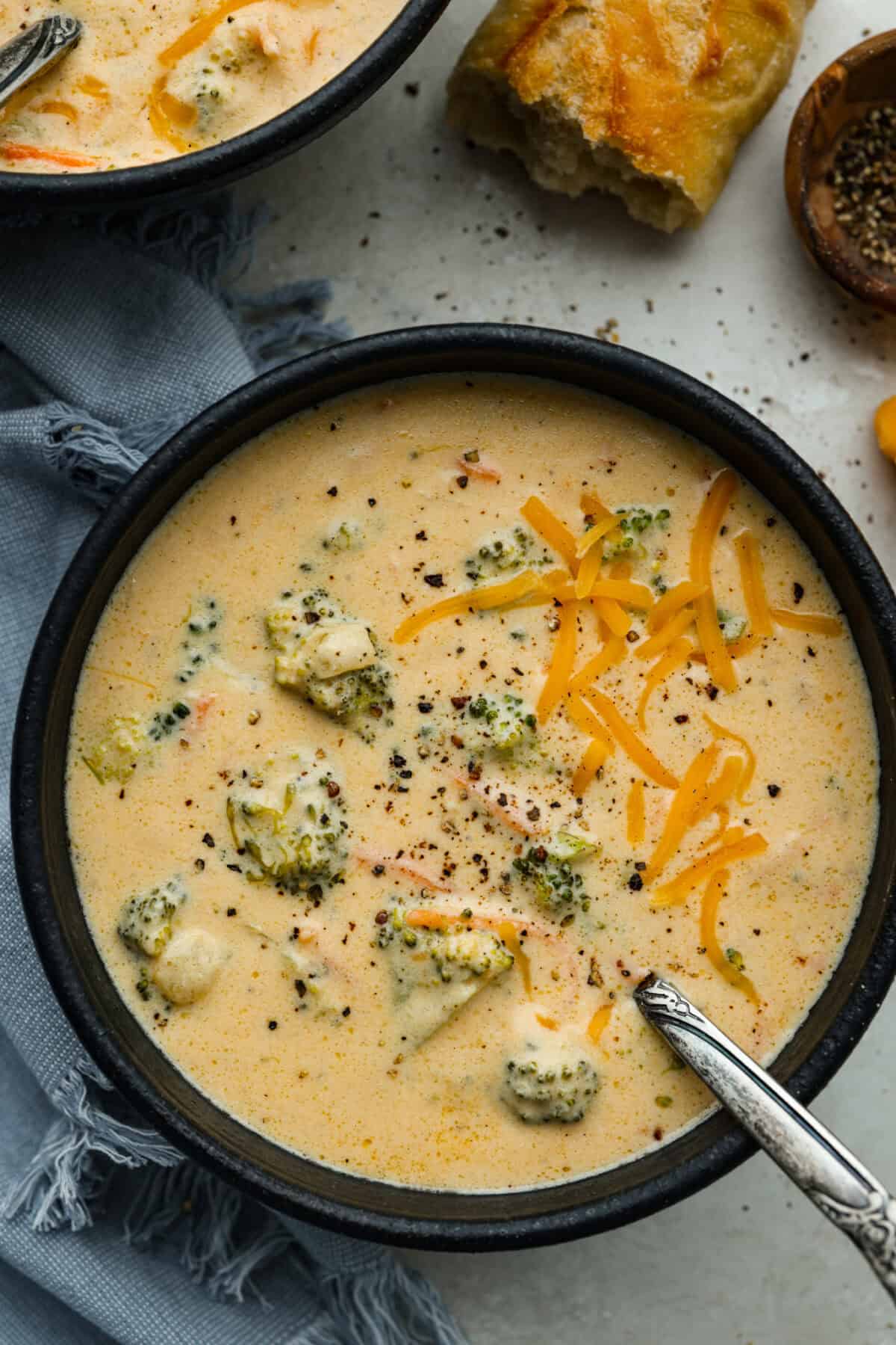 I promise that with just one bite of this copycat Panera Bread Broccoli Cheddar Soup, you'll be hooked! It's ultra creamy with broccoli, shredded carrots, and a hint of nutmeg, all cooked together with melted cheese. This soup is delicious and easy to make! Bowl of Panera broccoli cheese soup.