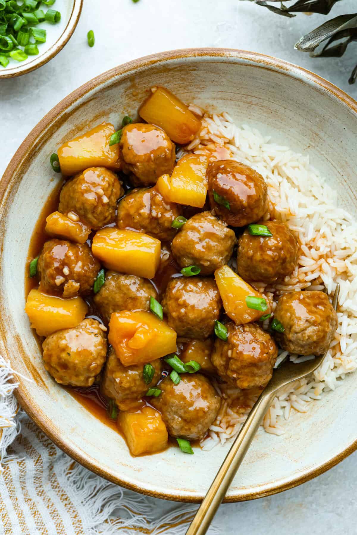 Image of plated crockpot huli huli meatballs with white rice. 