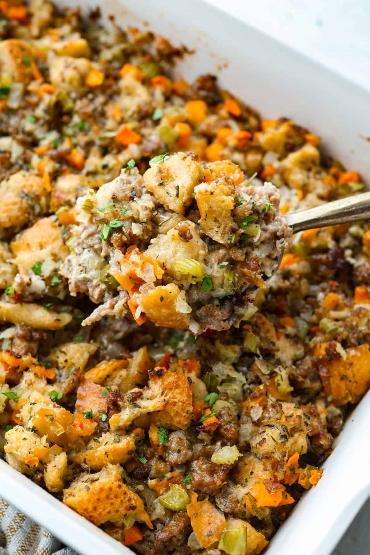 Why did it take me this long to use it in stuffing? Sourdough Stuffing's tangy crust and the chewy middle are perfection! Every bite soaks up all that buttery, herby goodness like it was made for this. Close up shot of baked sourdough stuffing.