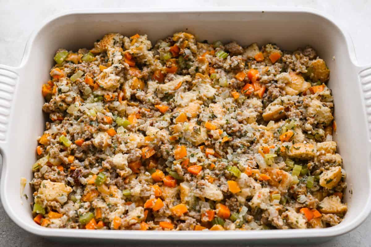 Why did it take me this long to use it in stuffing? Sourdough Stuffing's tangy crust and the chewy middle are perfection! Every bite soaks up all that buttery, herby goodness like it was made for this. Sourdough stuffing in the baking dish ready to go in the oven.