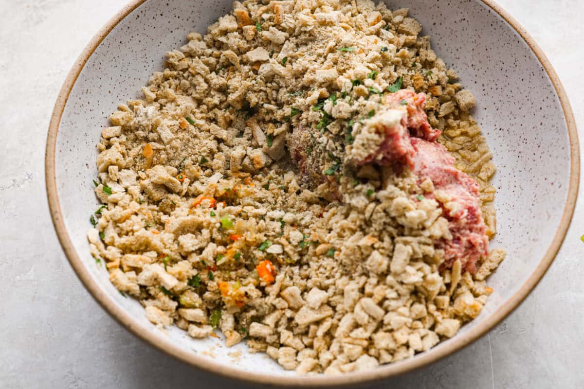 I'm telling you guys right now, sausage stuffing balls are the best part of my holiday table. They're crispy on the outside, soft and savory on the inside, and loaded with classic stuffing flavor. Easy to make, fun to share, and they disappear fast. Stuffing ad sausage added to a bowl with the cooked veggies.