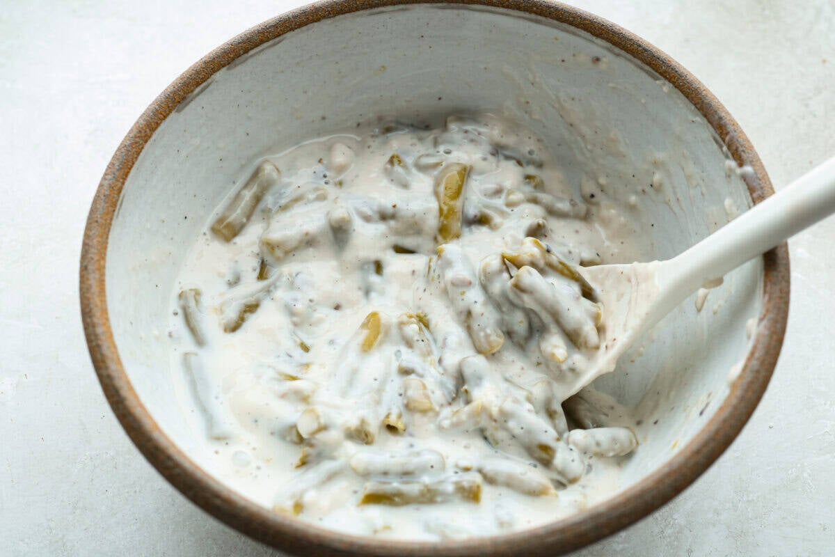 Thanksgiving doesn’t have to mean a long grocery list or an expensive spread. This 5-ingredient green bean casserole keeps things simple, affordable, and classic. It’s proof that comfort food doesn’t need a dozen ingredients. Ingredients mixed together in the mixing bowl.